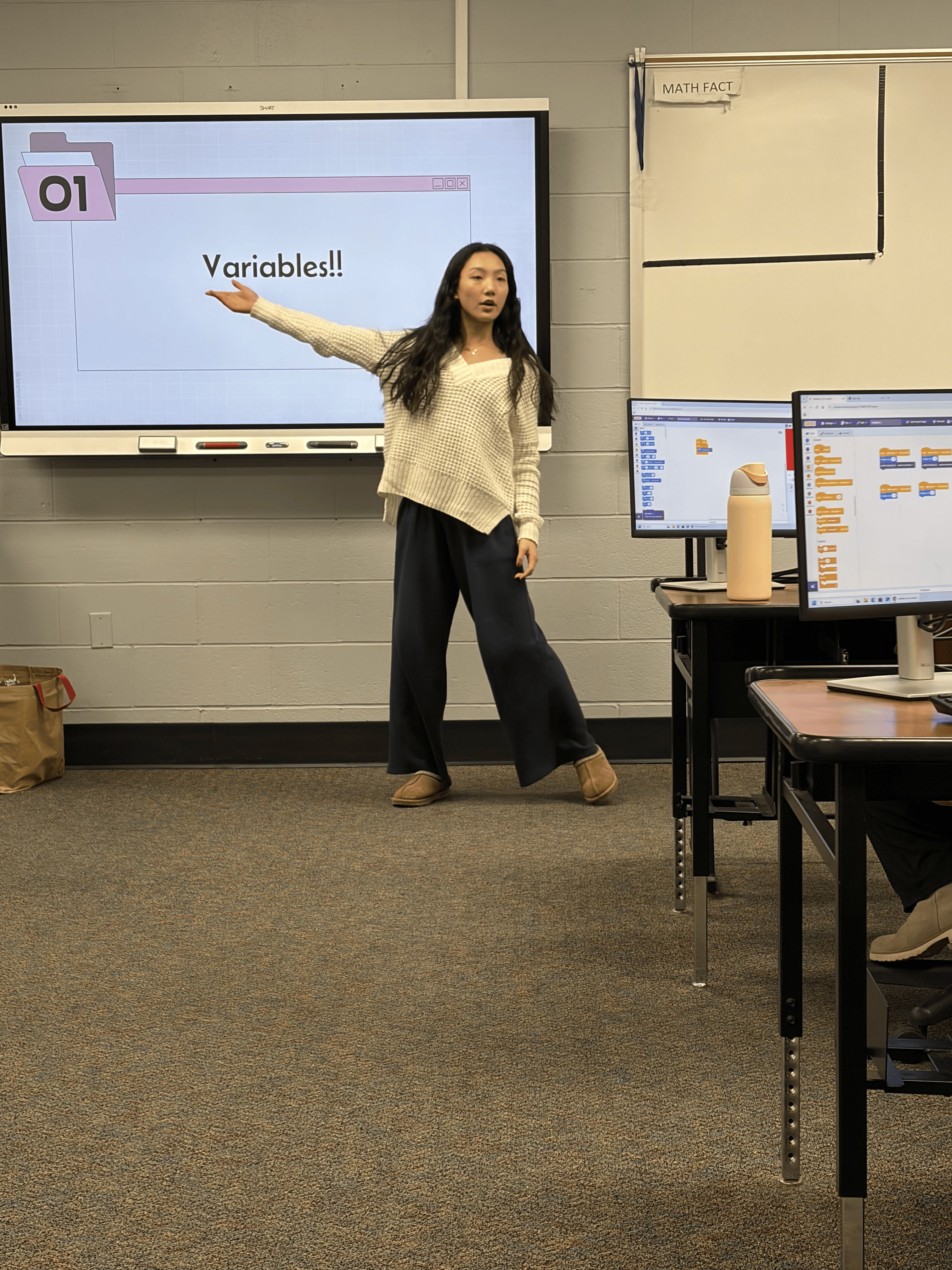 Volunteer teaching Variables lesson at the smart board